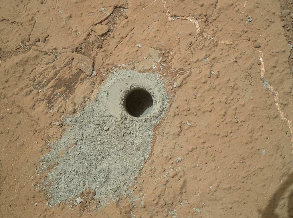 Curiosity’s Cumberland drill hole on Sol 279: a 1.6-centimeter gray borehole in pale mudstone, with fresh powder on the surface.